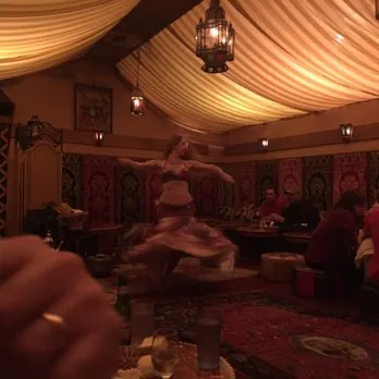 The tent room with cushions, lanterns and a dancer